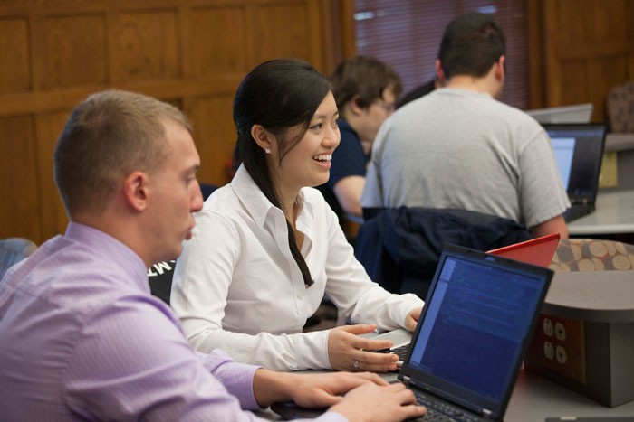 Smiling management students in class